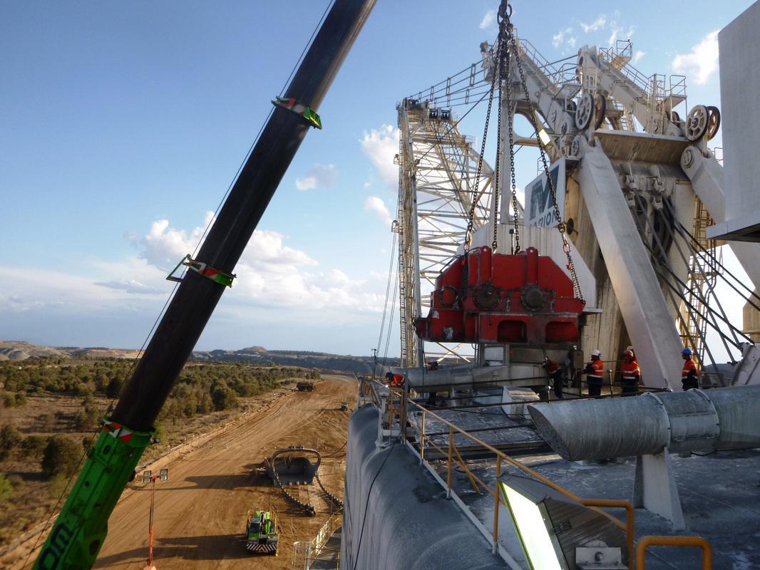 Crane lowering a red propel gear case onto the Marion 8750 dragline during an on-site change-out
