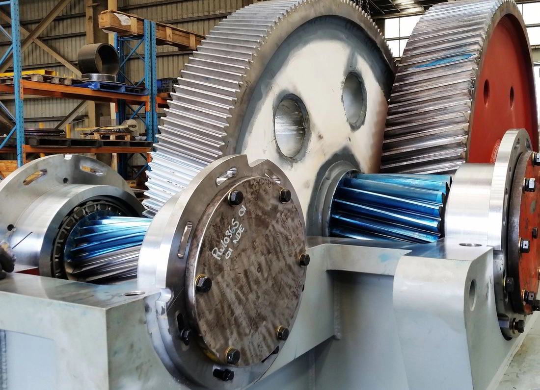 Large machined gear sets and slew assembly with blue coated helical gears in the workshop