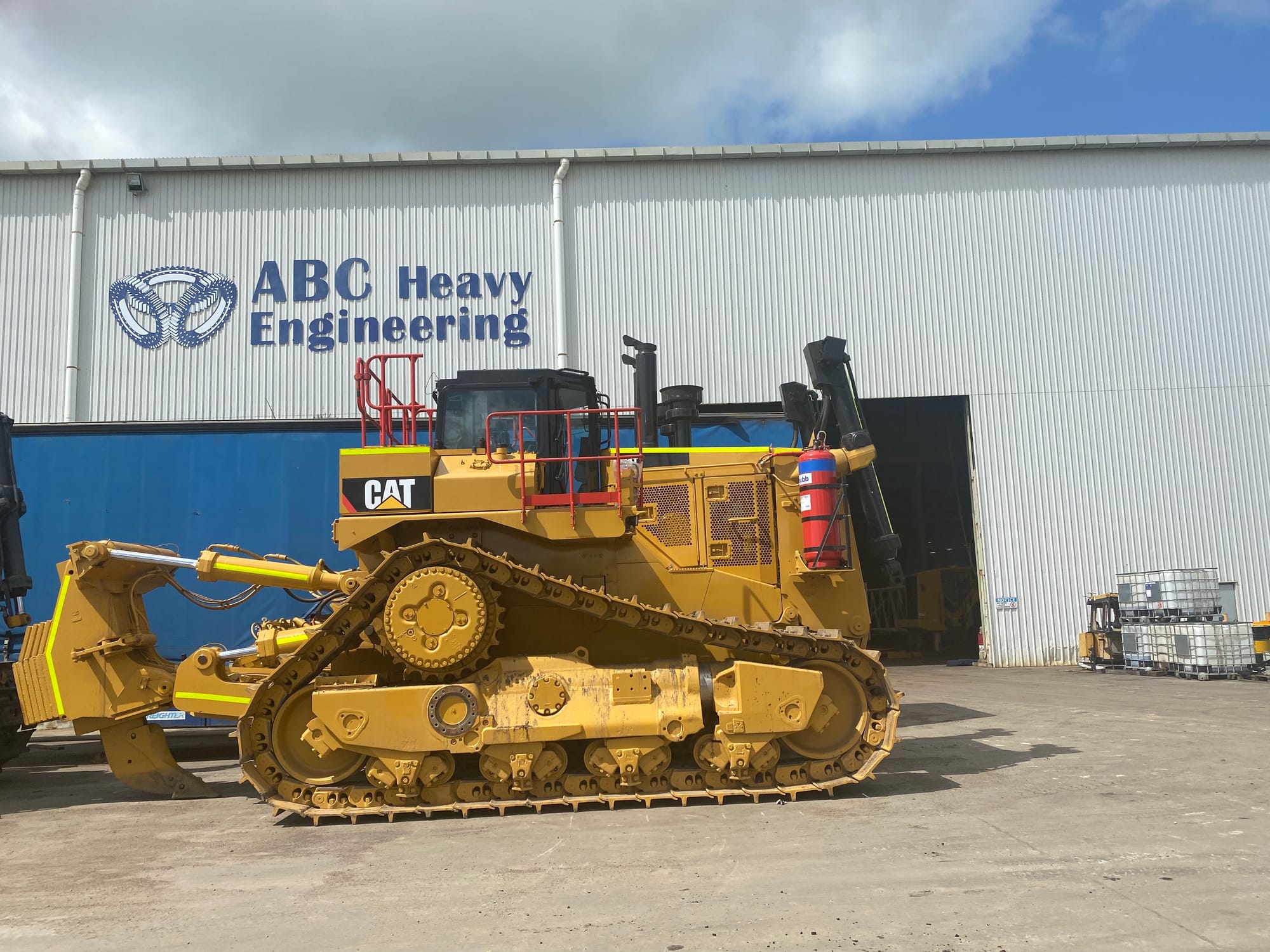 Large Caterpillar dozer parked at the signed ABC Heavy Engineering workshop