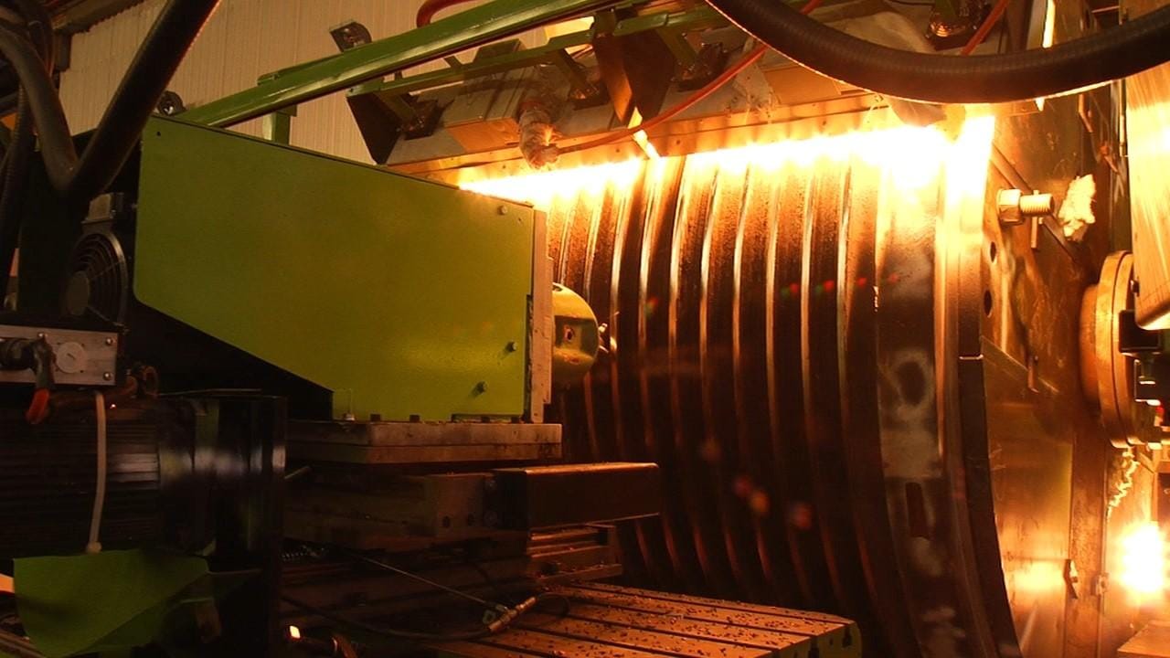 Induction heating rig set up around a large drum component in the ABC workshop